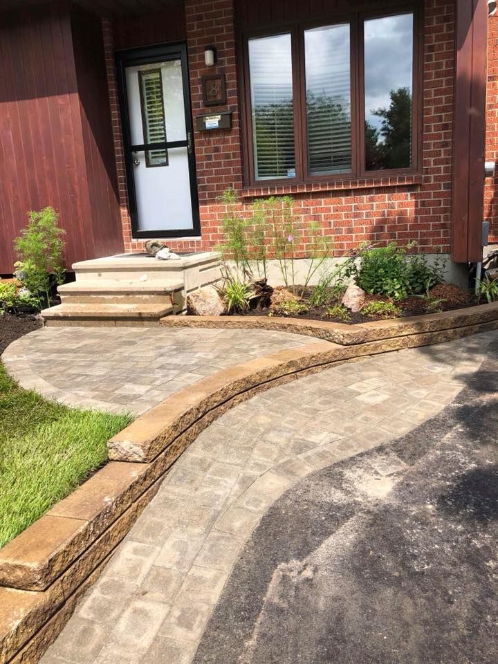 A walkway leading to the front door of a brick house.