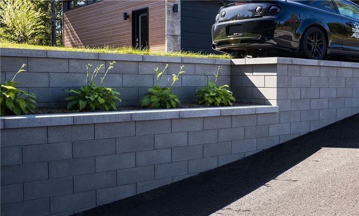 Une voiture est garée sur le côté d'un mur de briques.