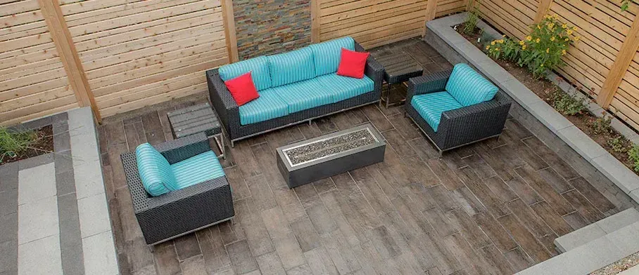 An aerial view of a patio with a couch , chairs , and a fire pit.