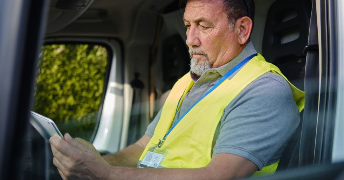 A transport driver uses a tablet inside a truck cab to review information and communicate during a shipment.