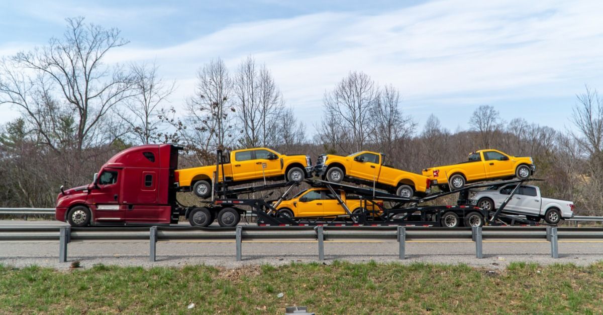 A car carrier transports several vehicles along a highway as part of a long-distance vehicle shipmen