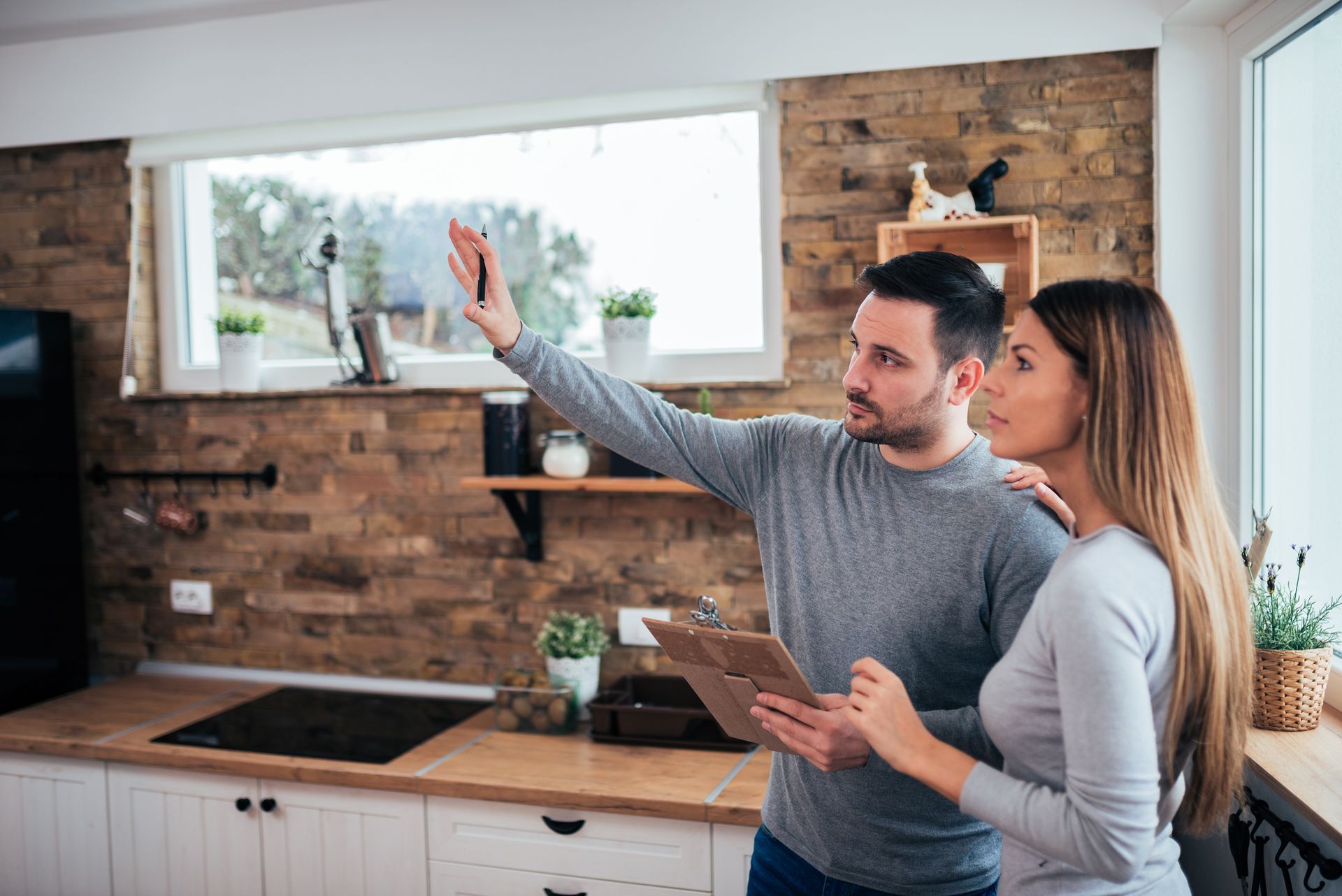 Couple discussing kitchen renovation ideas while standing in their kitchen.