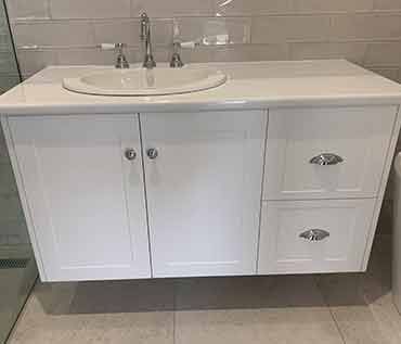 A bathroom vanity with a sink and drawers.