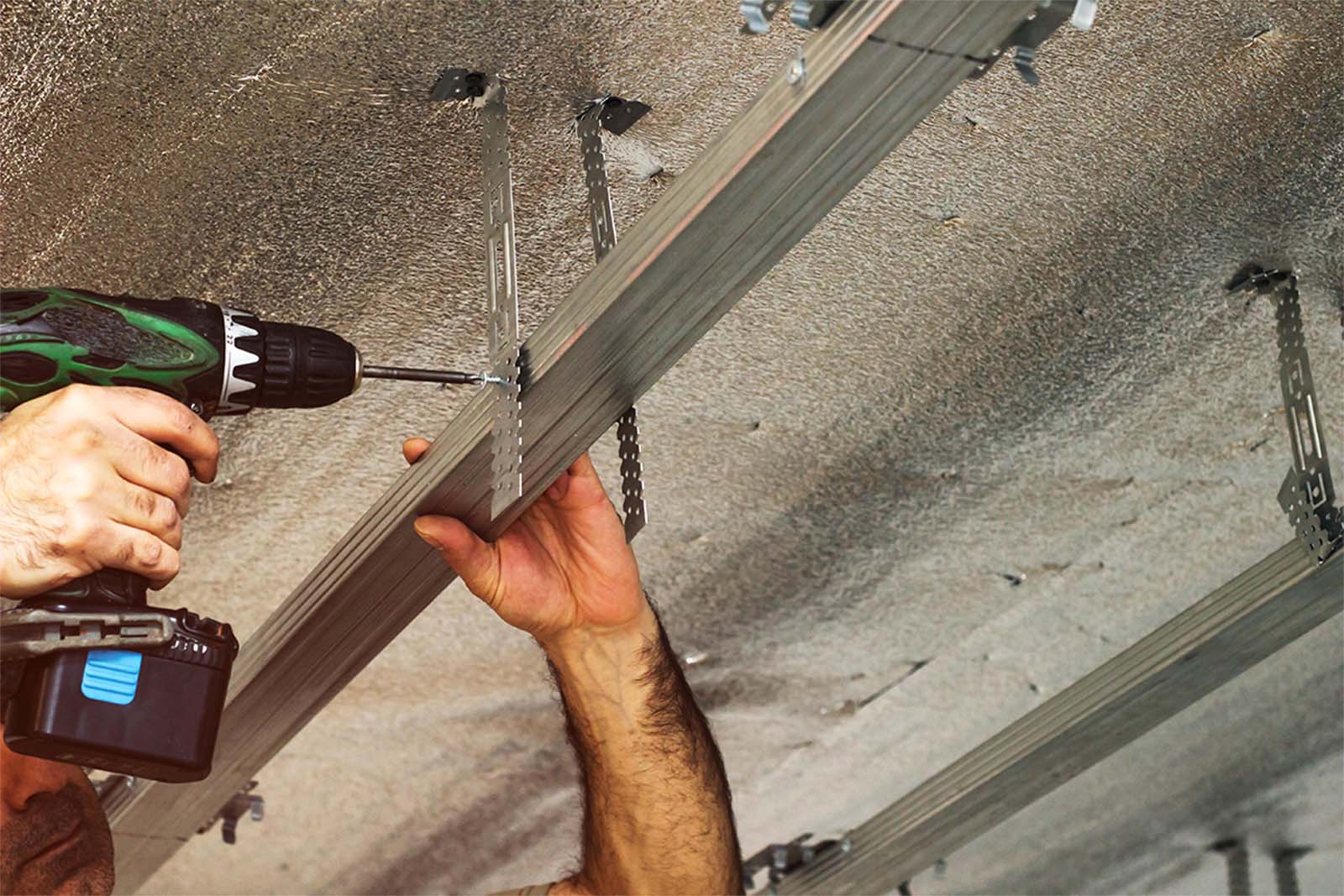 Plasterer Installing Metal Ceiling Battens In A Shed In Cairns