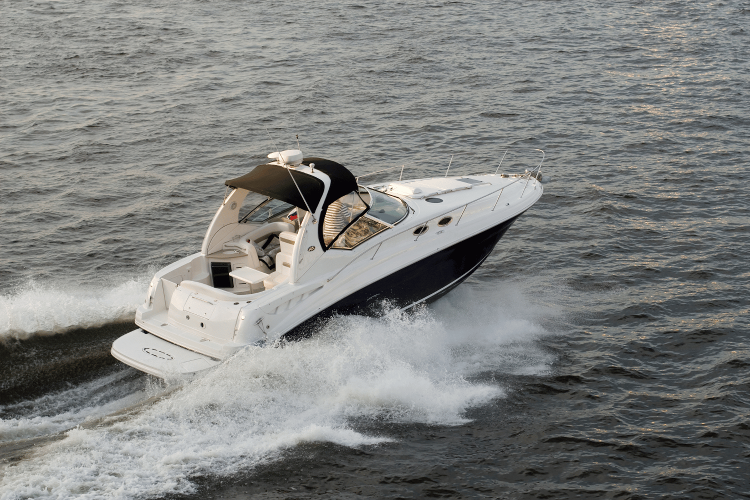 A white and black boat is floating on top of a body of water.