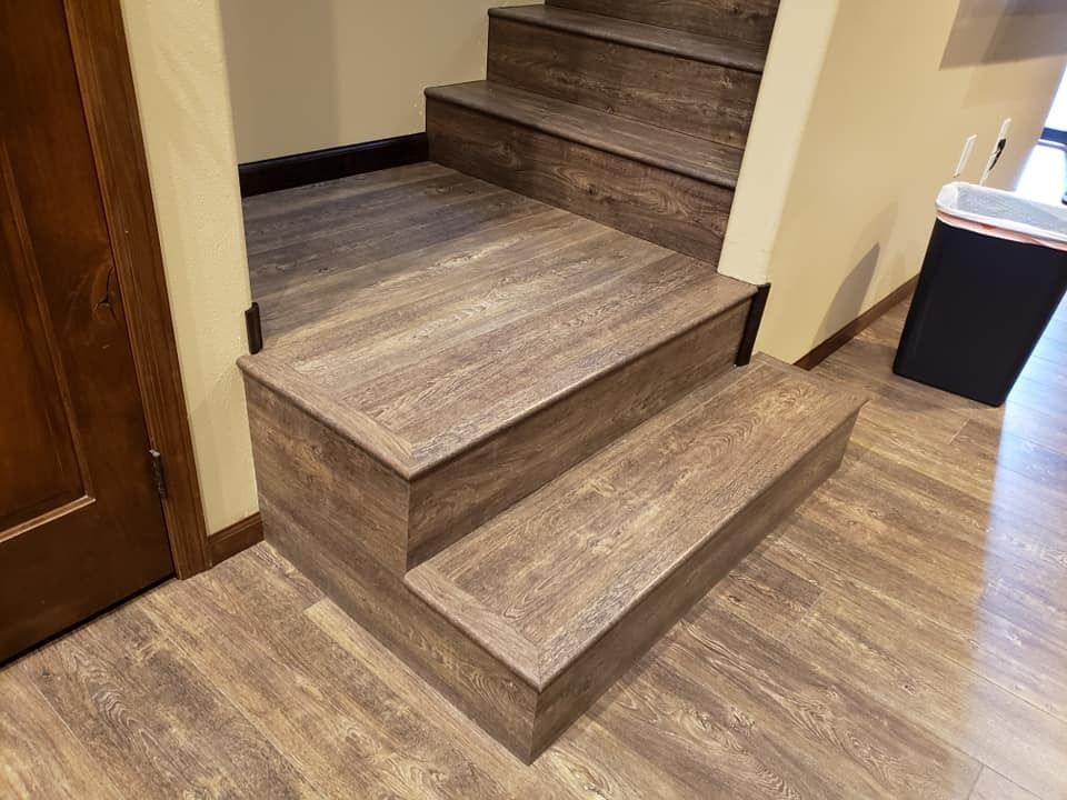 Wood-paneled staircase with wood-look flooring in a hallway.