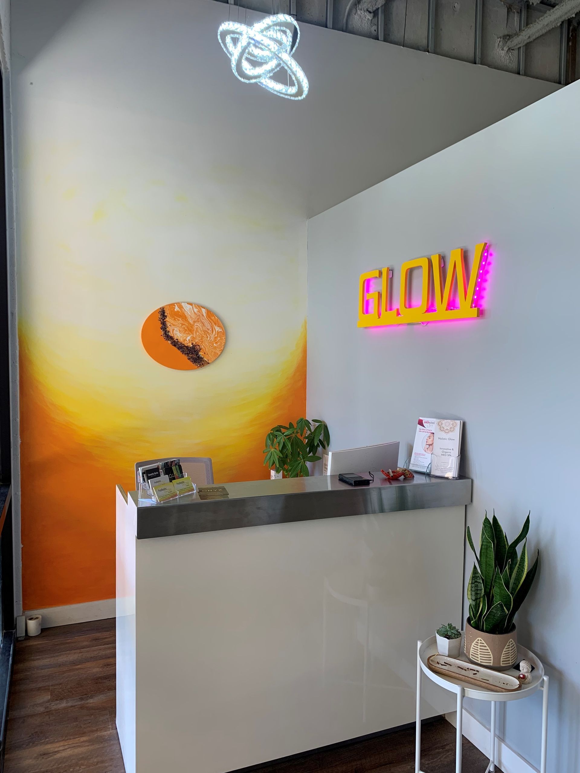 A reception area with a neon sign that says glow