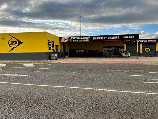 Dunlop Tire Shop Storefront With Yellow and Black Signage Along a Roadside — Mareeba Tyre Centre in Mareeba, QLD