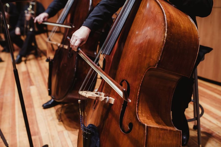 Cellists performing on stage with warm wooden instruments and bows in motion