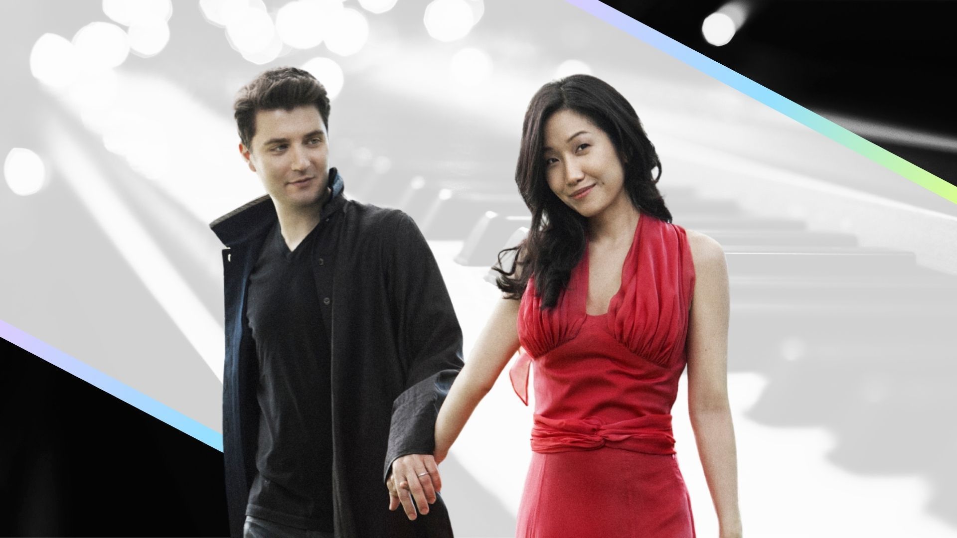 A smiling couple holding hands, walking against a bright abstract background.