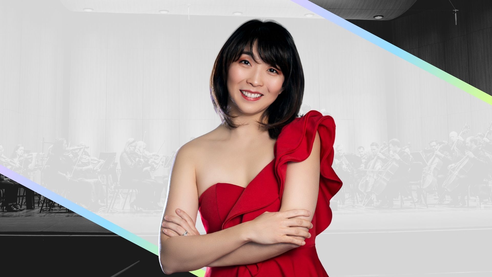 Smiling woman in a red dress with crossed arms against a gray, diagonal-striped background