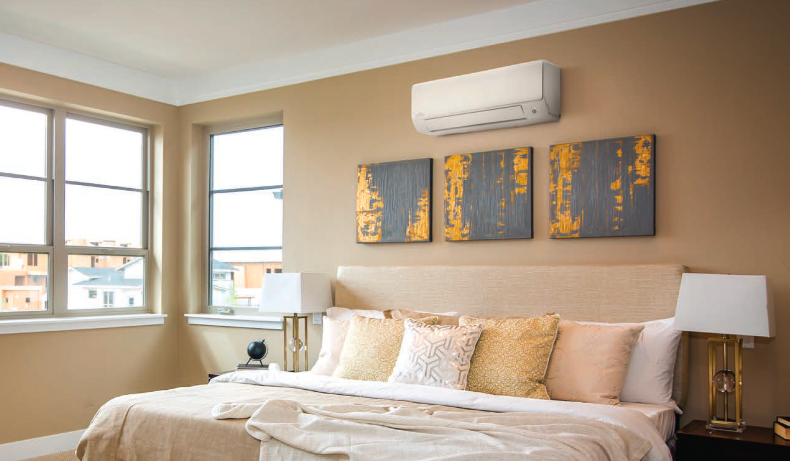 Chambre avec lit, œuvres d'art, fenêtres et climatiseur monté sur un mur beige.