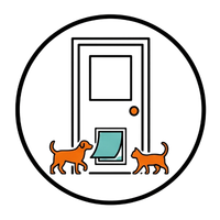 Two orange cats standing by a door, with a small open pet door at the bottom.
