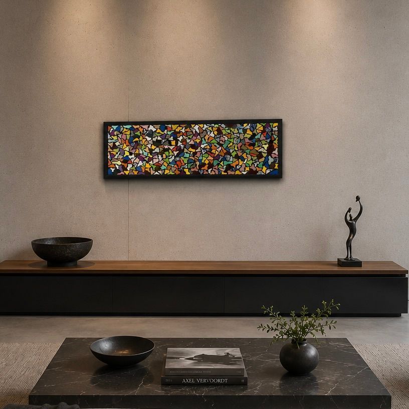 Minimalistische woonkamer met een lage zwarte bank, abstracte muurkunst en een donkere salontafel met decoratie.