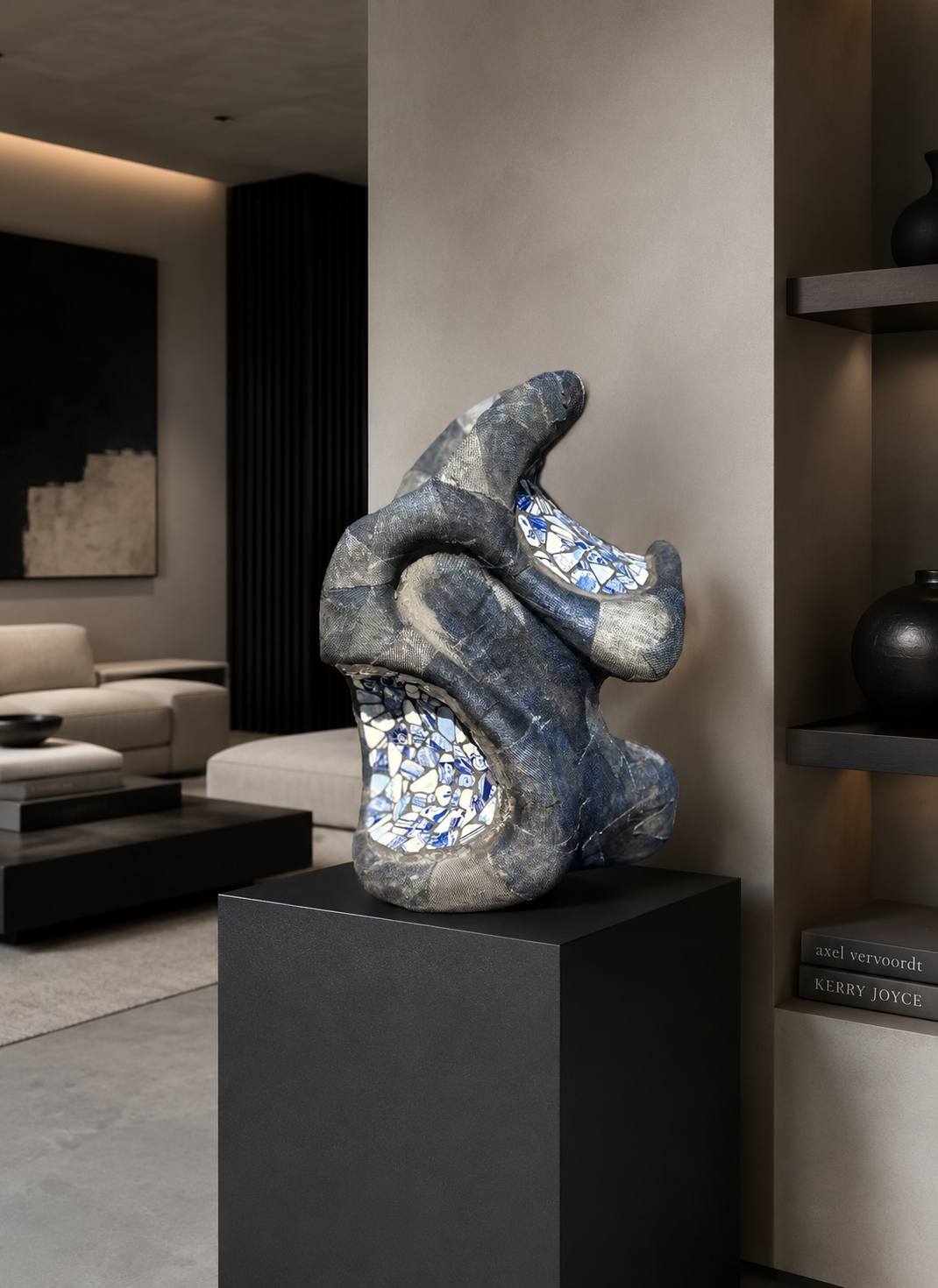 Abstracte blauw-zilveren sculptuur op een zwarte sokkel in een moderne woonkamer.