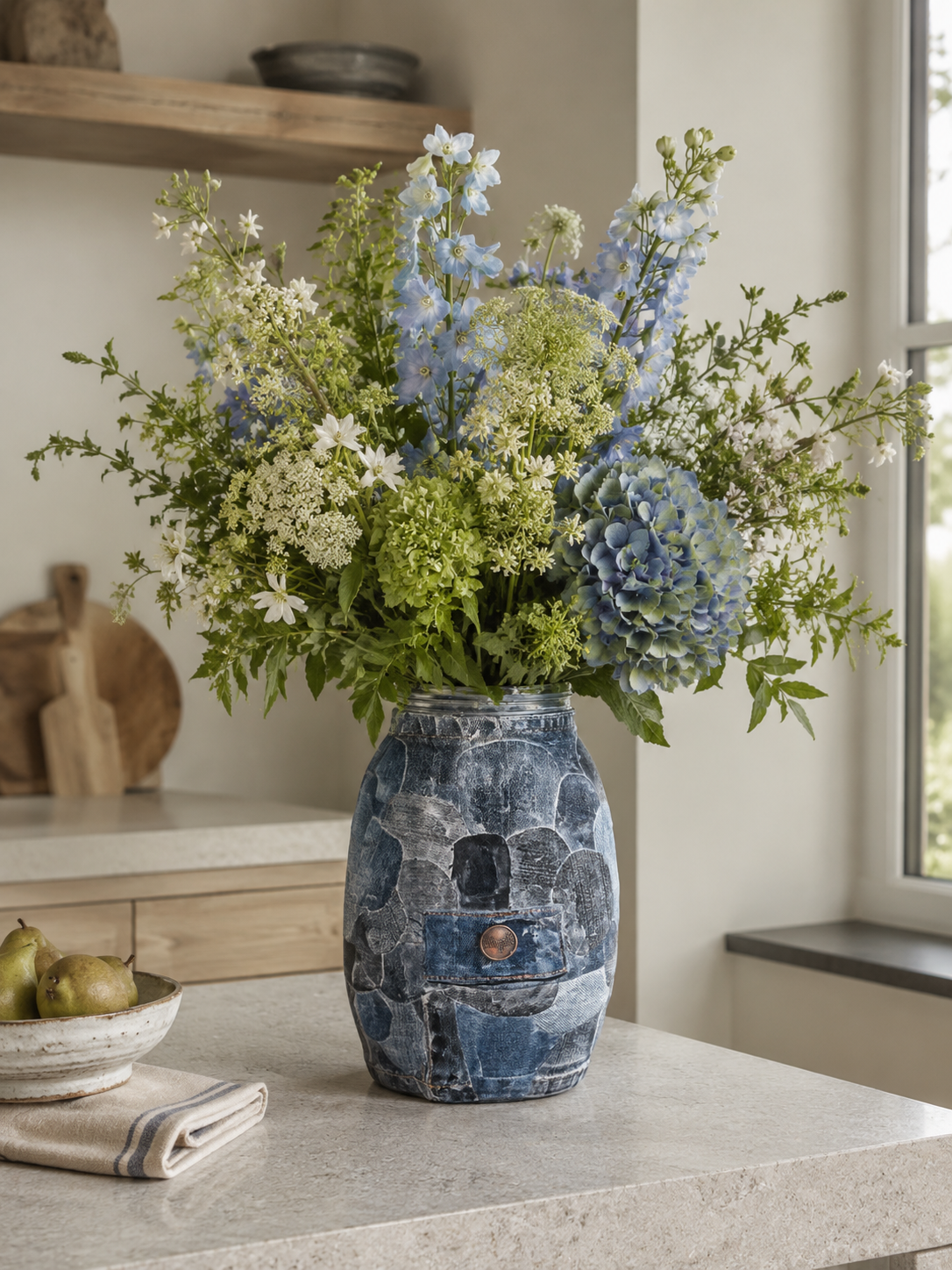 Blauwe vaas met witte en blauwe bloemen op het aanrecht bij het raam.