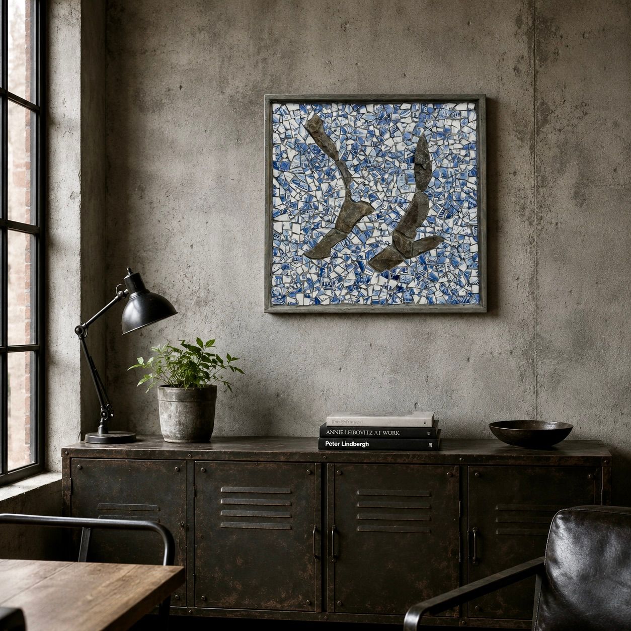 Een kamer in industriële stijl met betonnen muren, een donkere kast, een lamp, een plant en ingelijste abstracte kunstwerken.