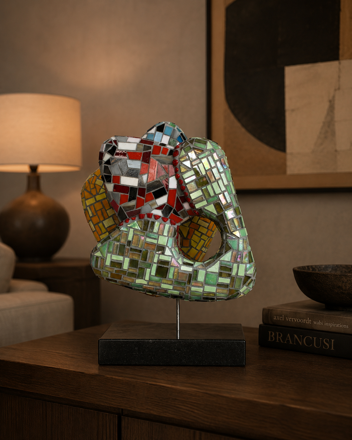 Mozaïek sculptuur van een menselijke buste op een tafel in een zacht verlichte kamer.