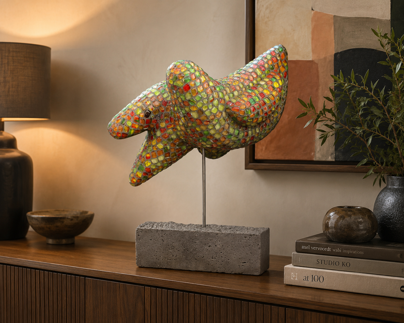 Een kleurrijk mozaïekbeeld van een vogel op een houten consoletafel, naast een lamp en ingelijste kunst.