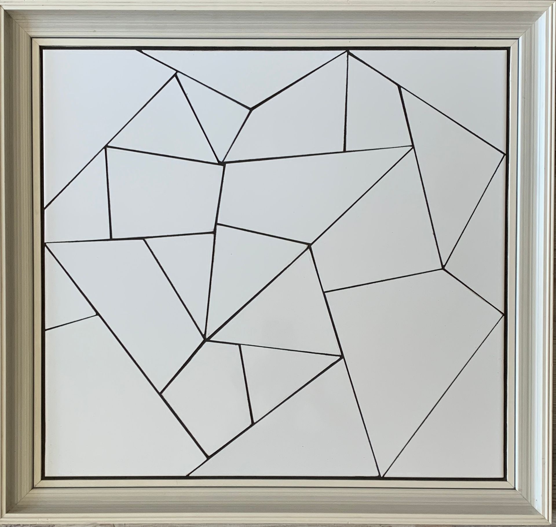Abstracte geometrische lijntekening in een witte houten lijst op een lichte achtergrond.