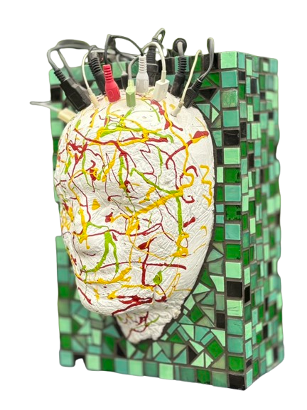 Abstracte sculptuur met een wit gezicht en kleurrijke draden bovenop een groene mozaïek sokkel.