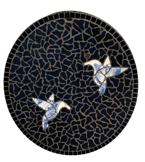 Twee blauw-witte vogels op een donker mozaïekbord.