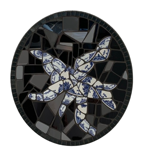 Abstracte cirkelvormige mozaïek met blauw-witte bladvormen op een zwarte achtergrond.