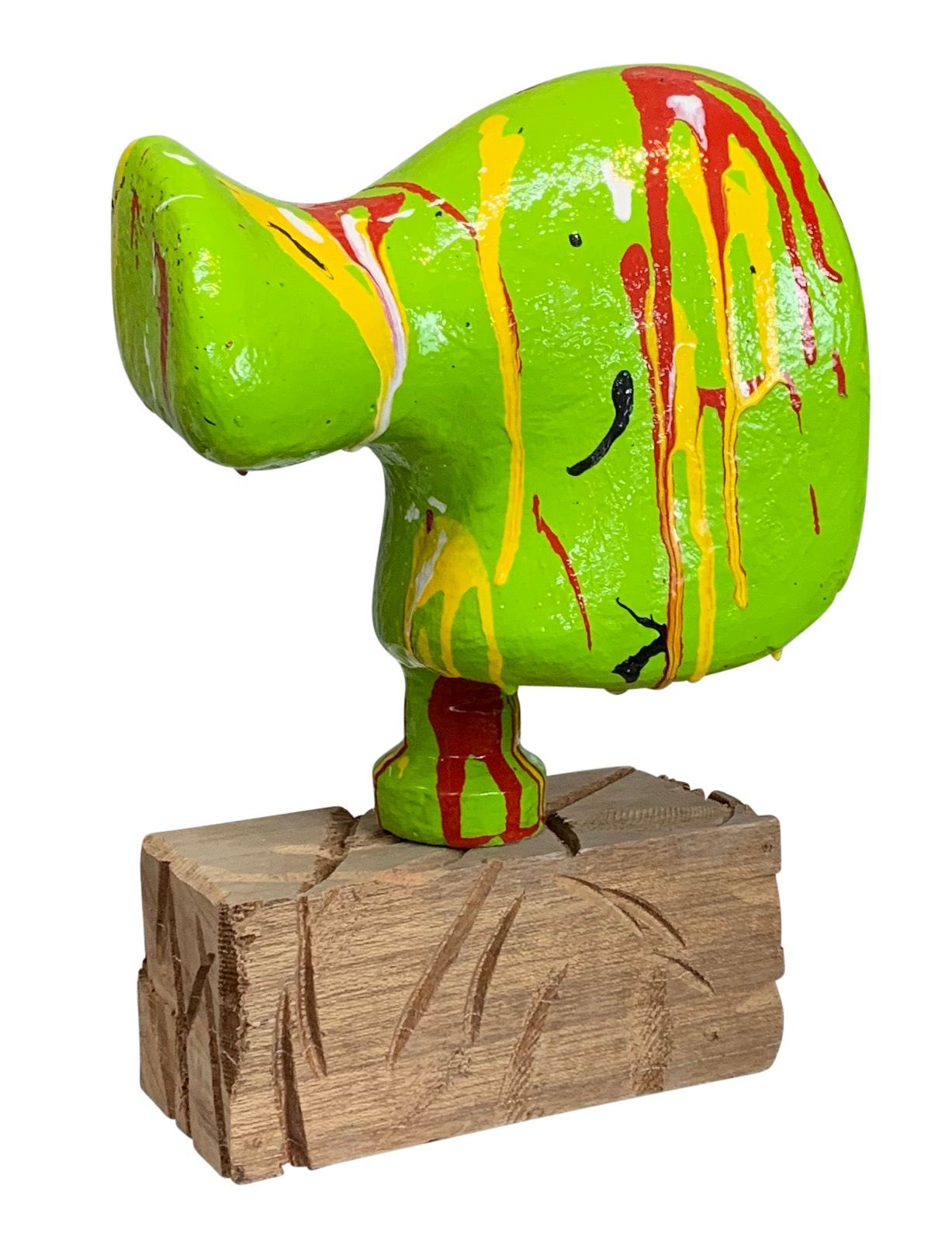 Een heldergroene abstracte sculptuur met rode en oranje verfspatten op een houten sokkel.
