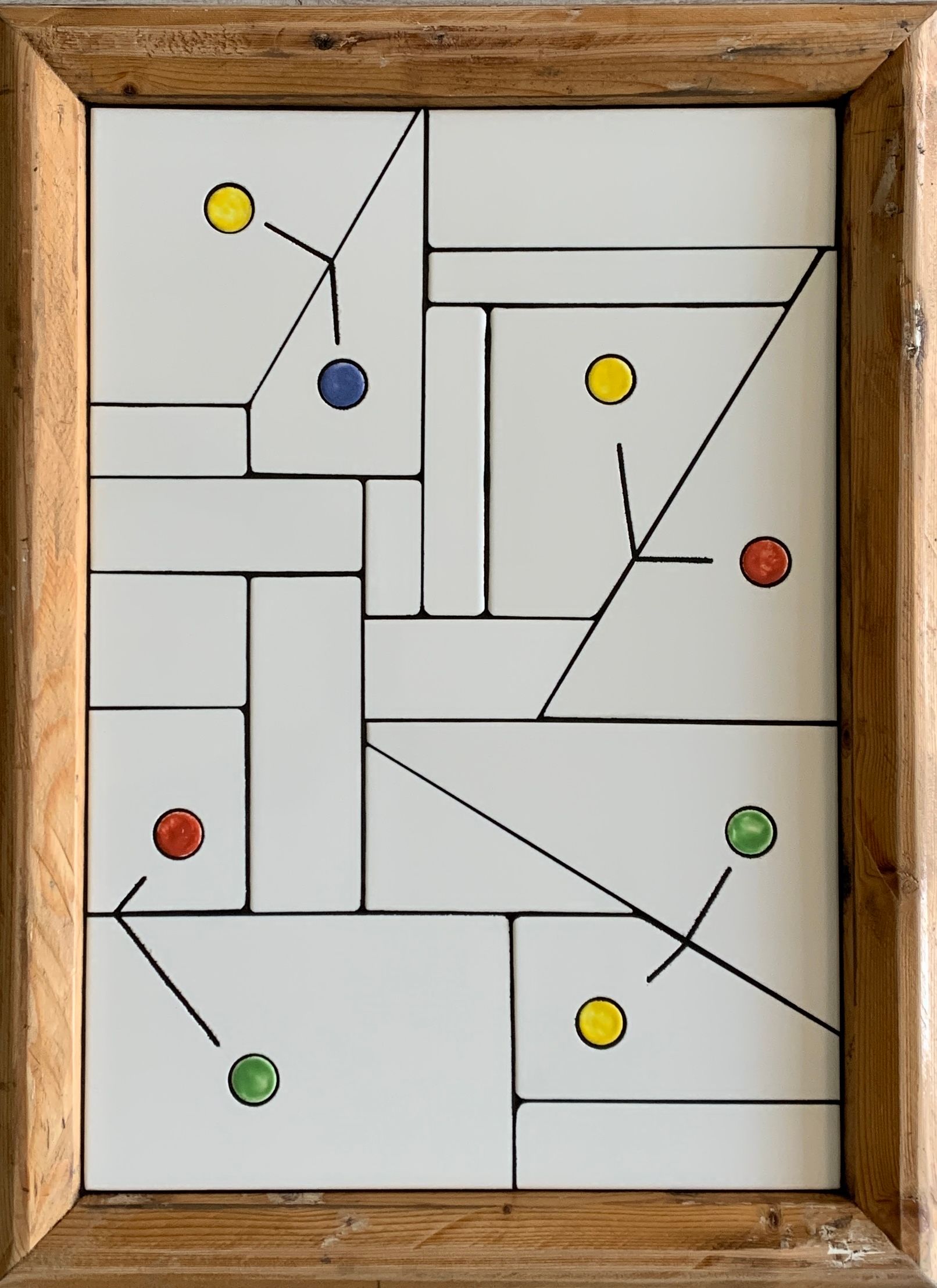 Abstracte geometrische puzzel met zes gekleurde stippen in een houten frame.