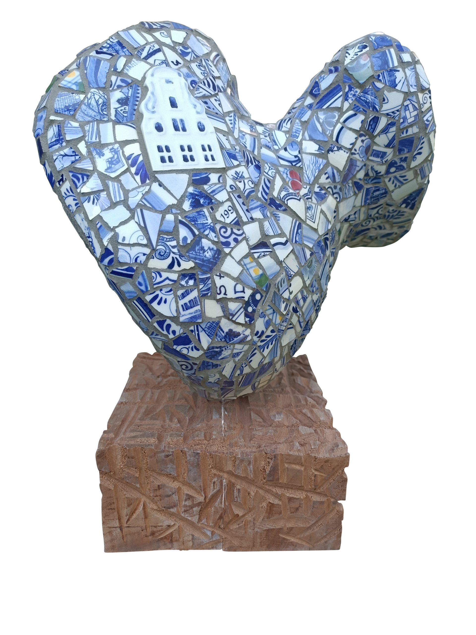 Blauw-wit mozaïek hartsculptuur op een houten sokkel.