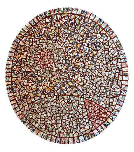 Rond, mozaïekachtig abstract patroon in rood, blauw en bruin op een witte achtergrond.