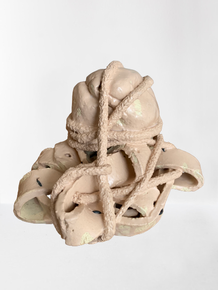Beige gevlochten sculptuur, lijkend op een kleine knoop, geïsoleerd op een witte achtergrond.