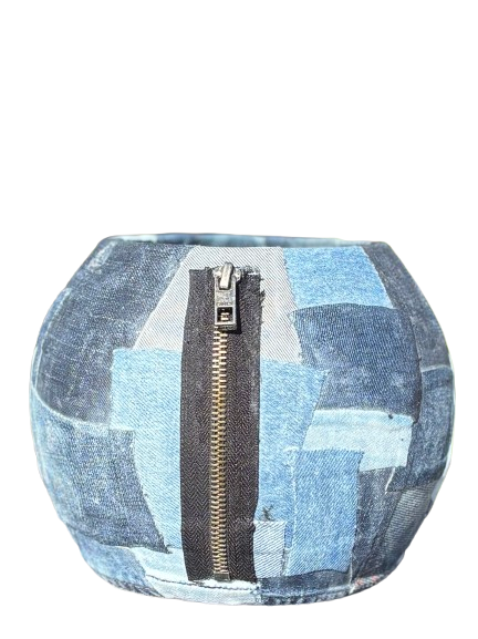 Blauwe patchwork handtas met een verticale ritssluiting in het midden.
