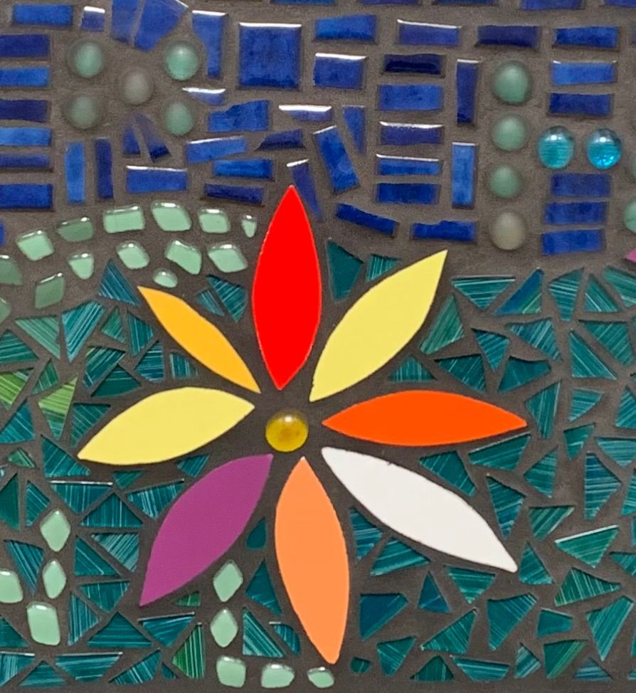Kleurrijke mozaïekbloem met zeven blaadjes op een abstracte tegelachtergrond in blauw en turquoise.