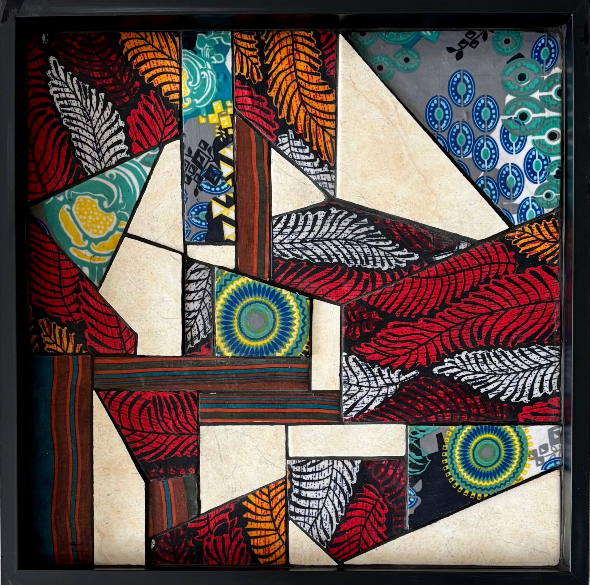 Abstracte geometrische quilt met driehoeken en vierkanten van stof in de kleuren rood, blauw, crème en zwart.