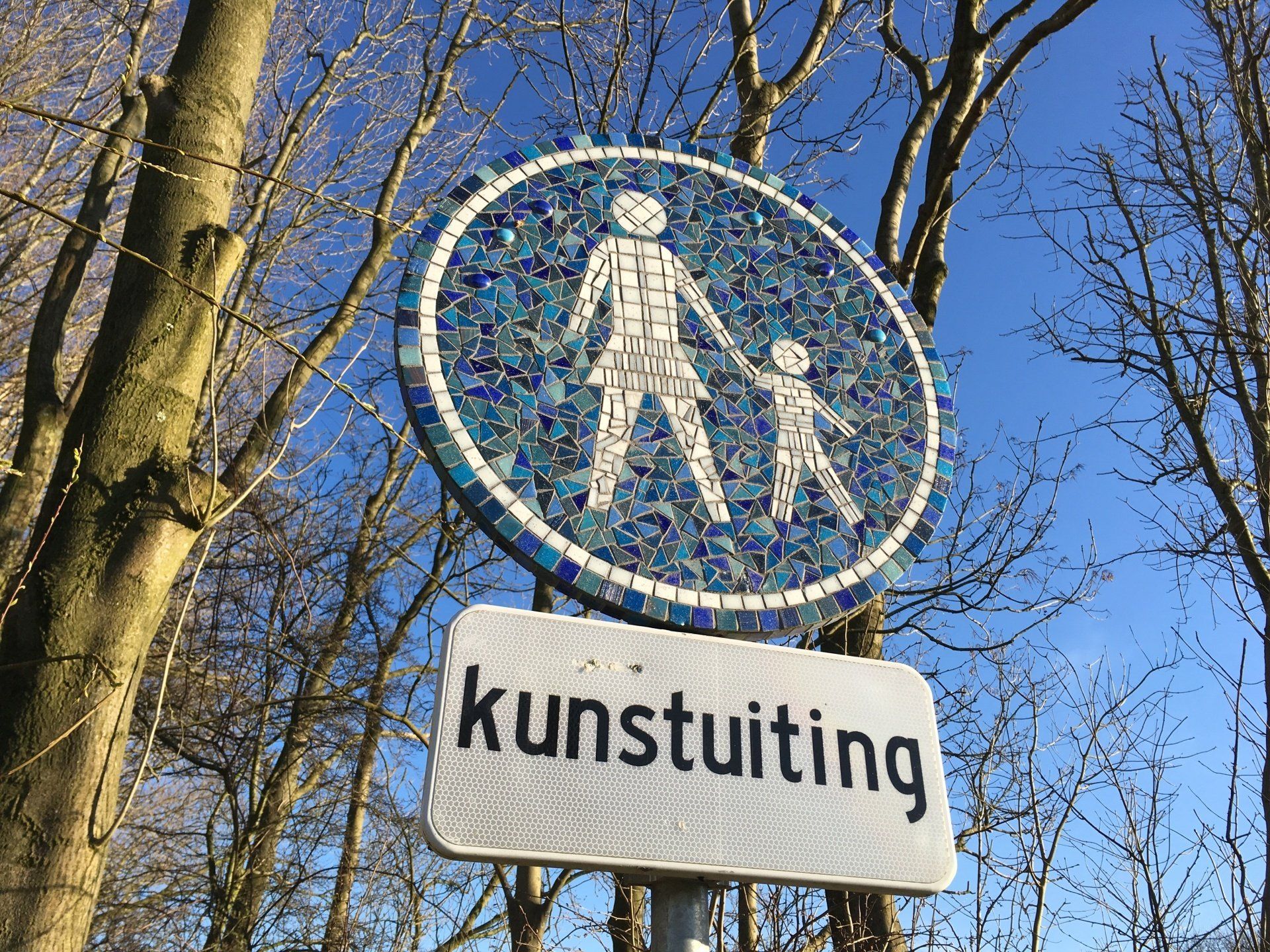 Blauw voetgangersbord boven een