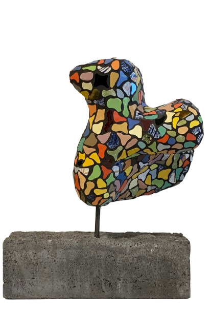 Kleurrijke mozaïek vogelsculptuur op een betonnen sokkel, geïsoleerd op een witte achtergrond.