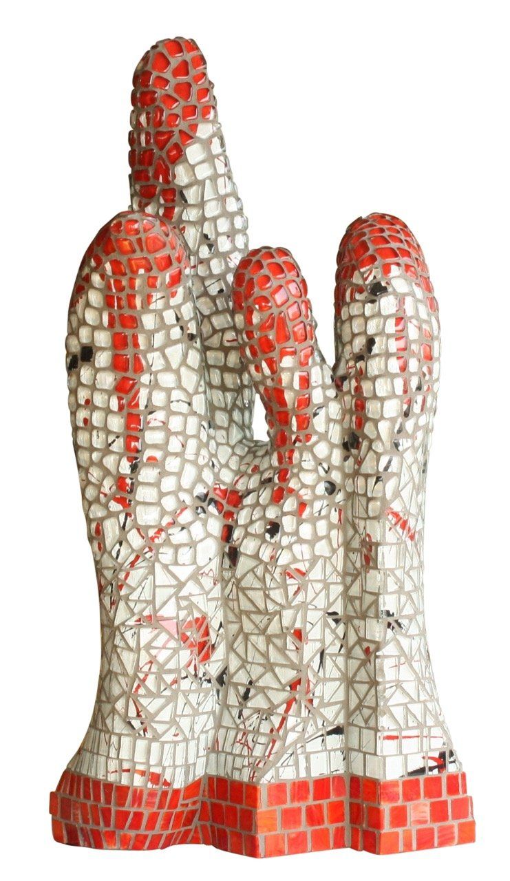 Abstracte mozaïeksculptuur met drie witte, rood betegelde verticale vormen op een sokkel, die lijken op rotsachtige pilaren.