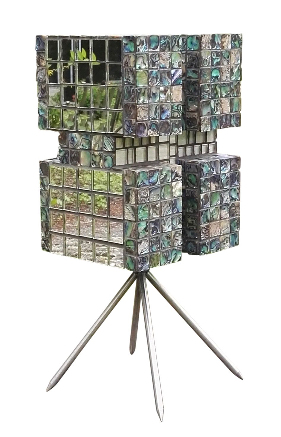 Een met mozaïek bedekte kubussculptuur op een driepoot, gemaakt van kleine spiegelende en gedessineerde tegels.
