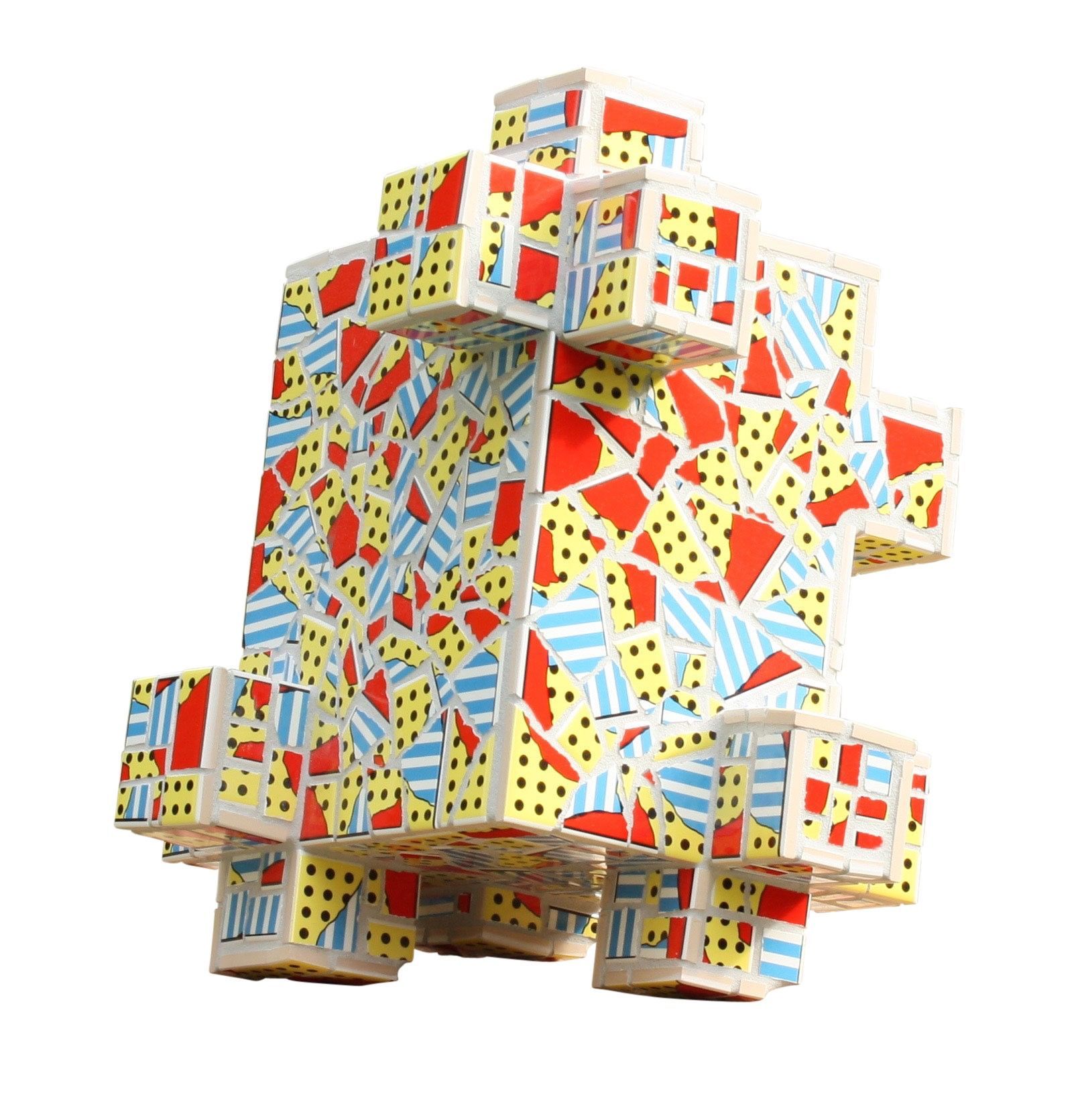 Kleurrijke abstracte geometrische sculptuur met rode, blauwe, gele en witte panelen op een witte achtergrond.