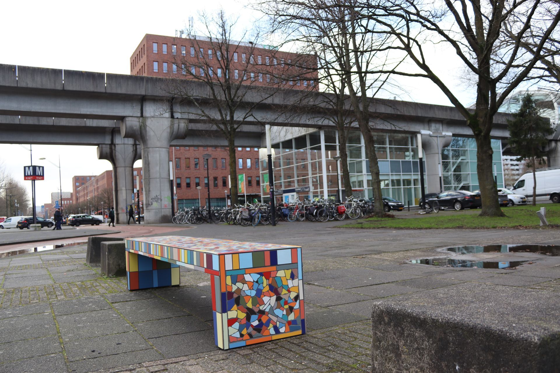Een kleurrijke mozaïekbank op een stadsplein. 