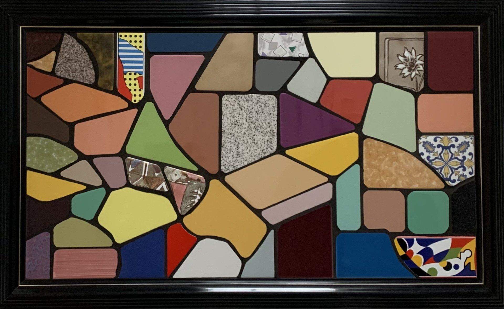 Abstracte mozaïek van kleurrijke, onregelmatige tegels, gerangschikt in een omlijst patroon.