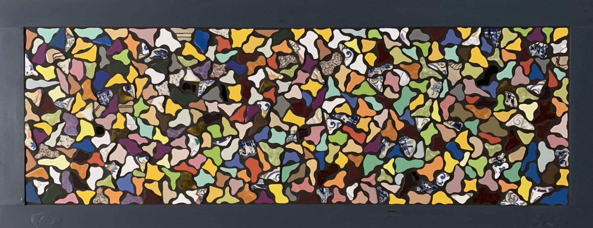 Kleurrijk abstract mozaïek van kleine, onregelmatige vormen in blauw, geel, oranje, groen en zwart.