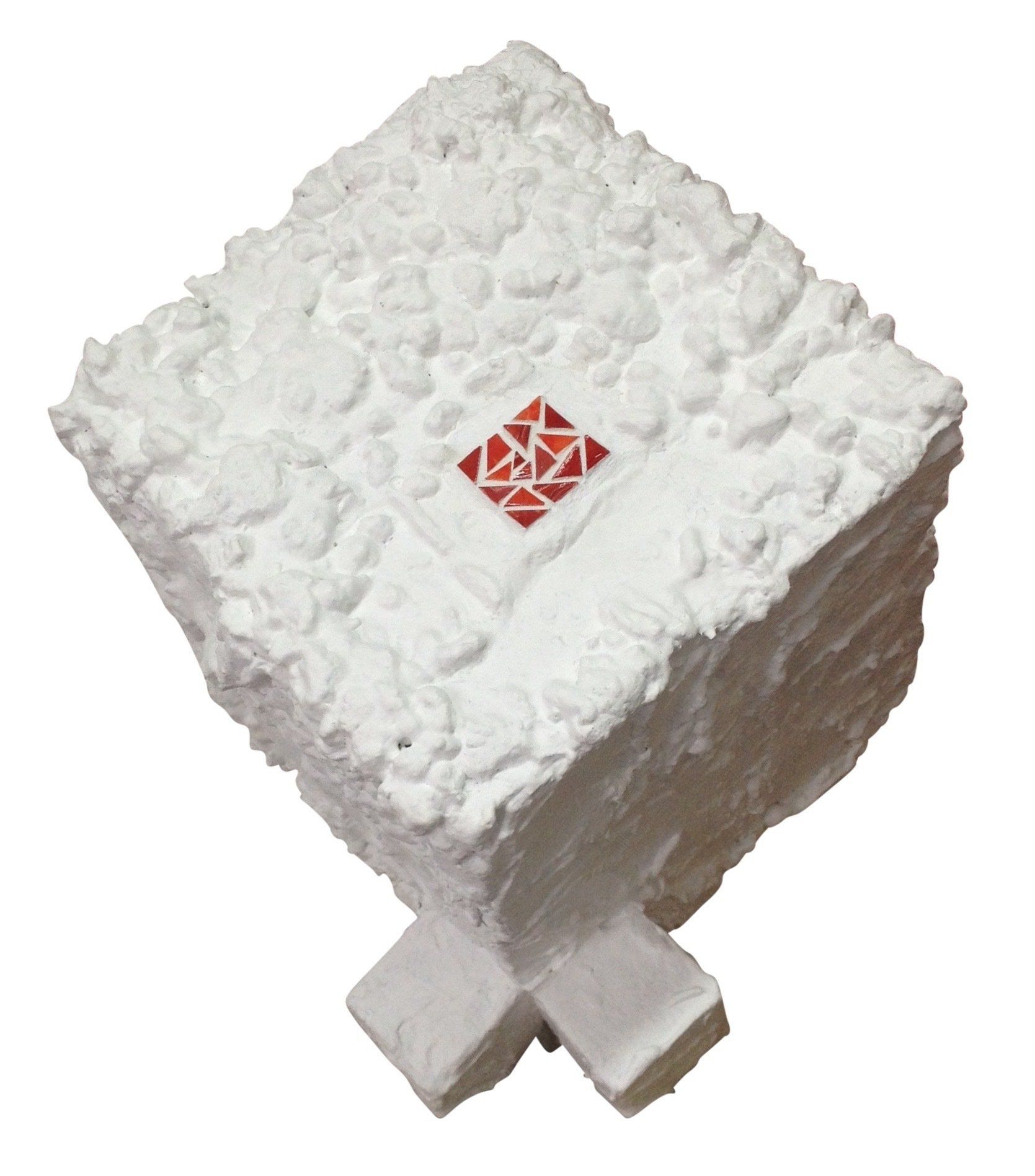 Witte, pluizige, vierkante kruk met gekruiste poten en een klein rood geometrisch embleem erop.