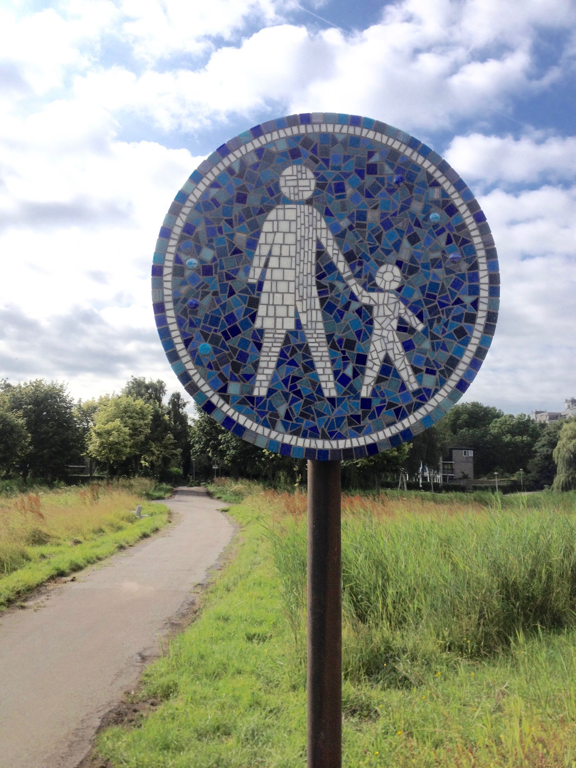 Mozaïek voetgangersbord met een afbeelding van een volwassene die de hand van een kind vasthoudt.
