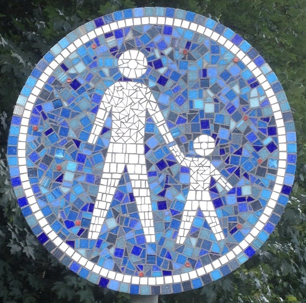 Blauw mozaïek voetgangersbord met witte volwassen en kinderfiguren in een cirkel.