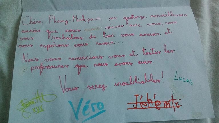 Carte de remerciement manuscrite sur papier blanc, à l'encre rouge, verte et bleue, signée par plusieurs personnes.