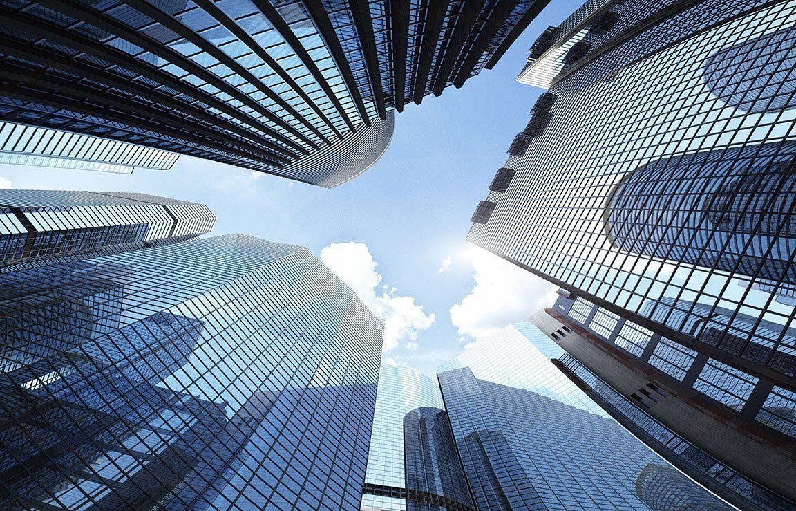 Skyscrapers reaching into a bright blue sky with a few white clouds.