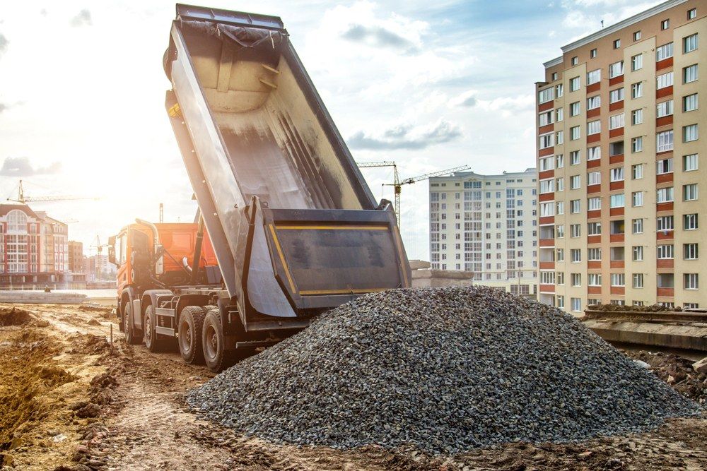 A Dump Truck is Dumping Gravel on a Construction Site — Jammach Earthmoving in Newcastle, NSW