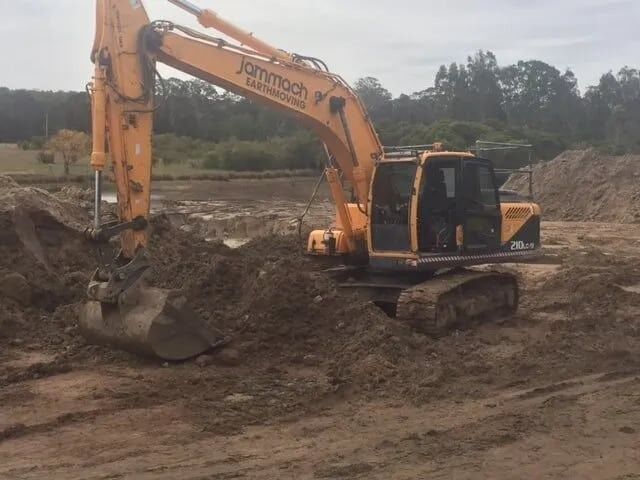 A Yellow Branded Jammach Earthmoving Excavator — Jammach Earthmoving in Mid North Coast, NSW